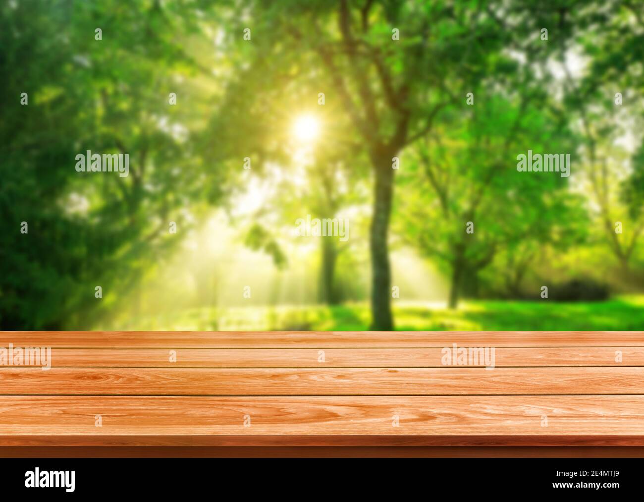 Brown wood table in green blur nature background of trees and grass in the park with empty copy space on the table for product display mockup. Fresh Stock Photo