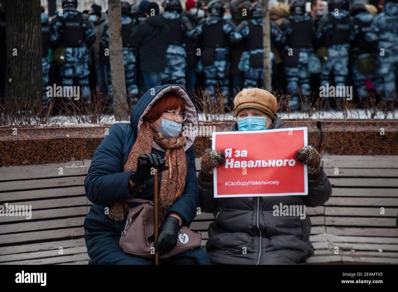 Moscow, Russia. 23rd of January, 2021 Women sit on a bench on the Pushkinskaya Square during an unauthorized political rally in support of opposition leader Alexei Navalny in Moscow, Russia. The banner reads 'I support Navalny' Stock Photo