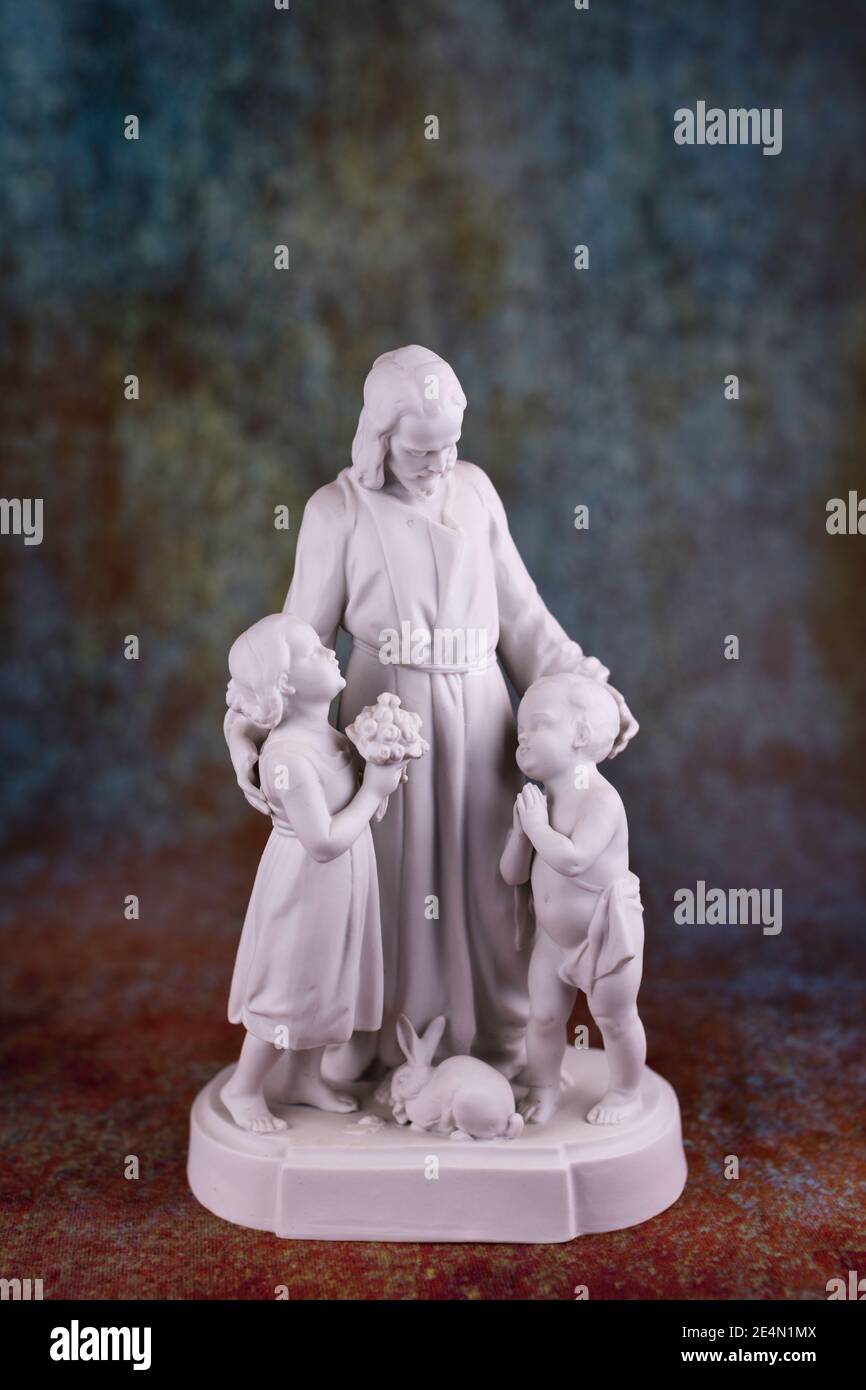 Early 20th C statuette of Jesus and two children in porcelain. Stock Photo