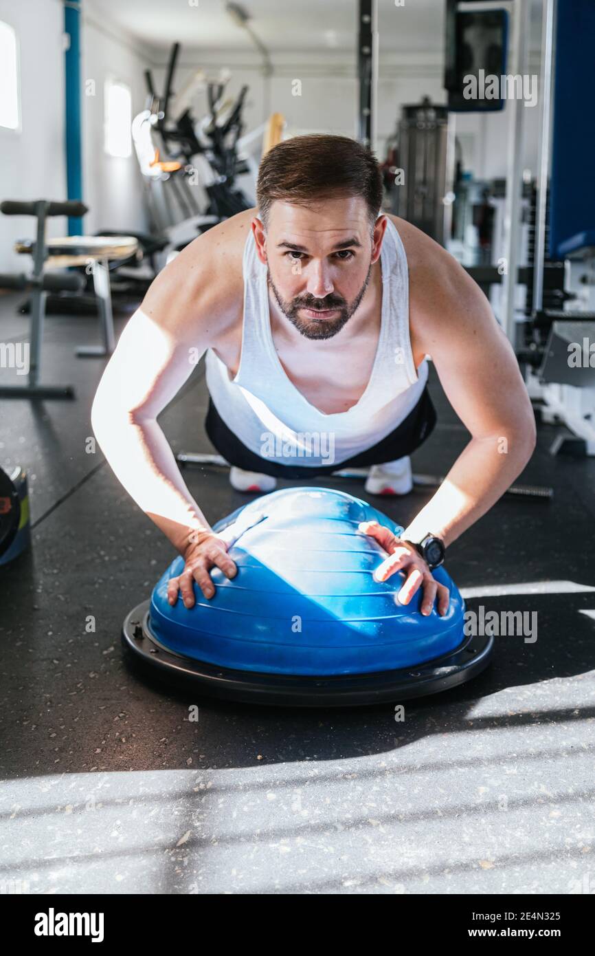 Man exercising on bosu ball in the gym.Health and wellness concept. Sport Stock Photo Alamy