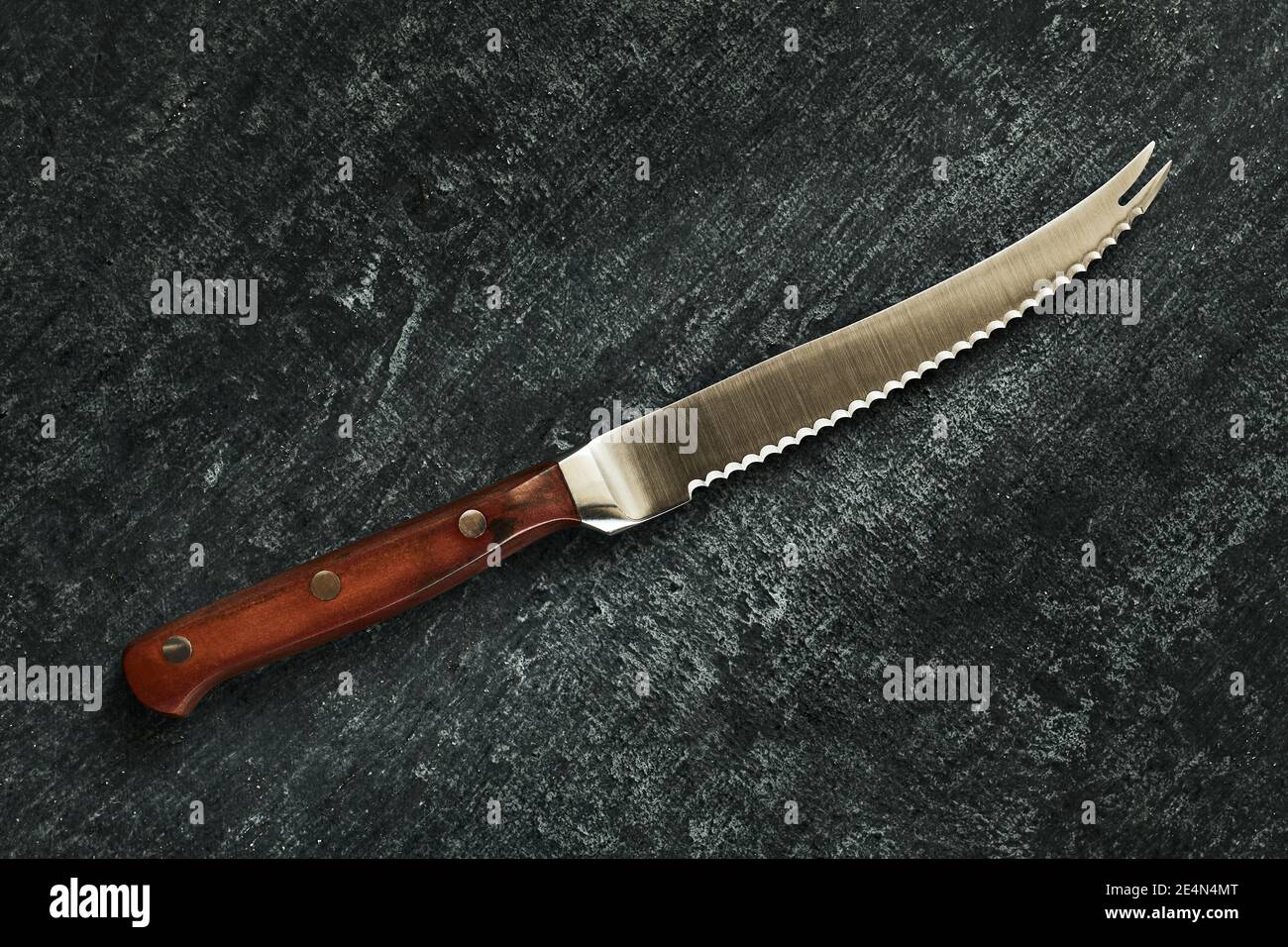 Specialized chefs kitchen tomato knife on gray grunge background, close up, top view Stock Photo
