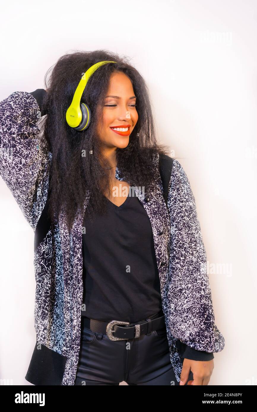 A vertical closeup of a happy smiling Hispanic female enjoying music ...