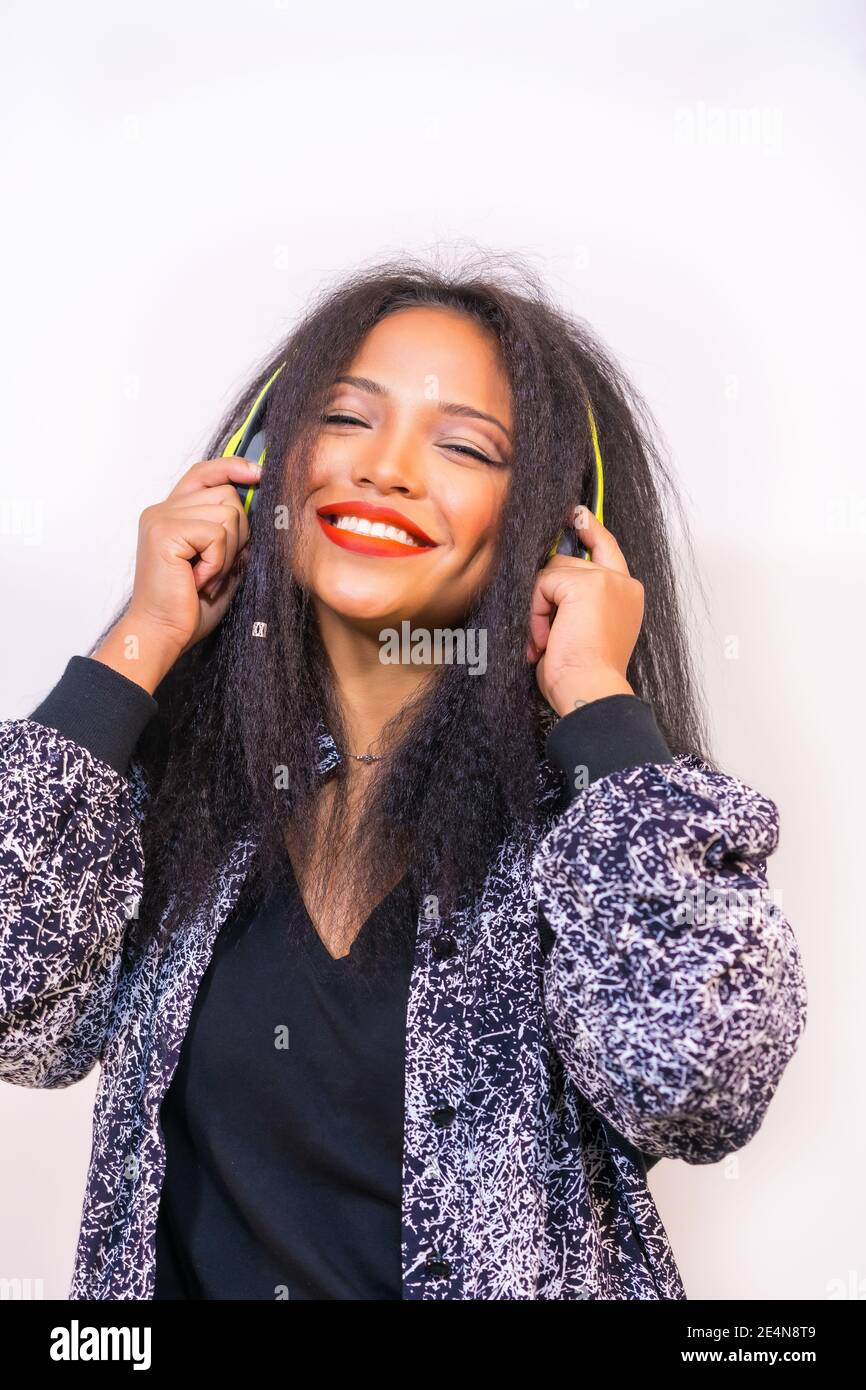 A vertical closeup of a pretty young Hispanic female enjoying music ...