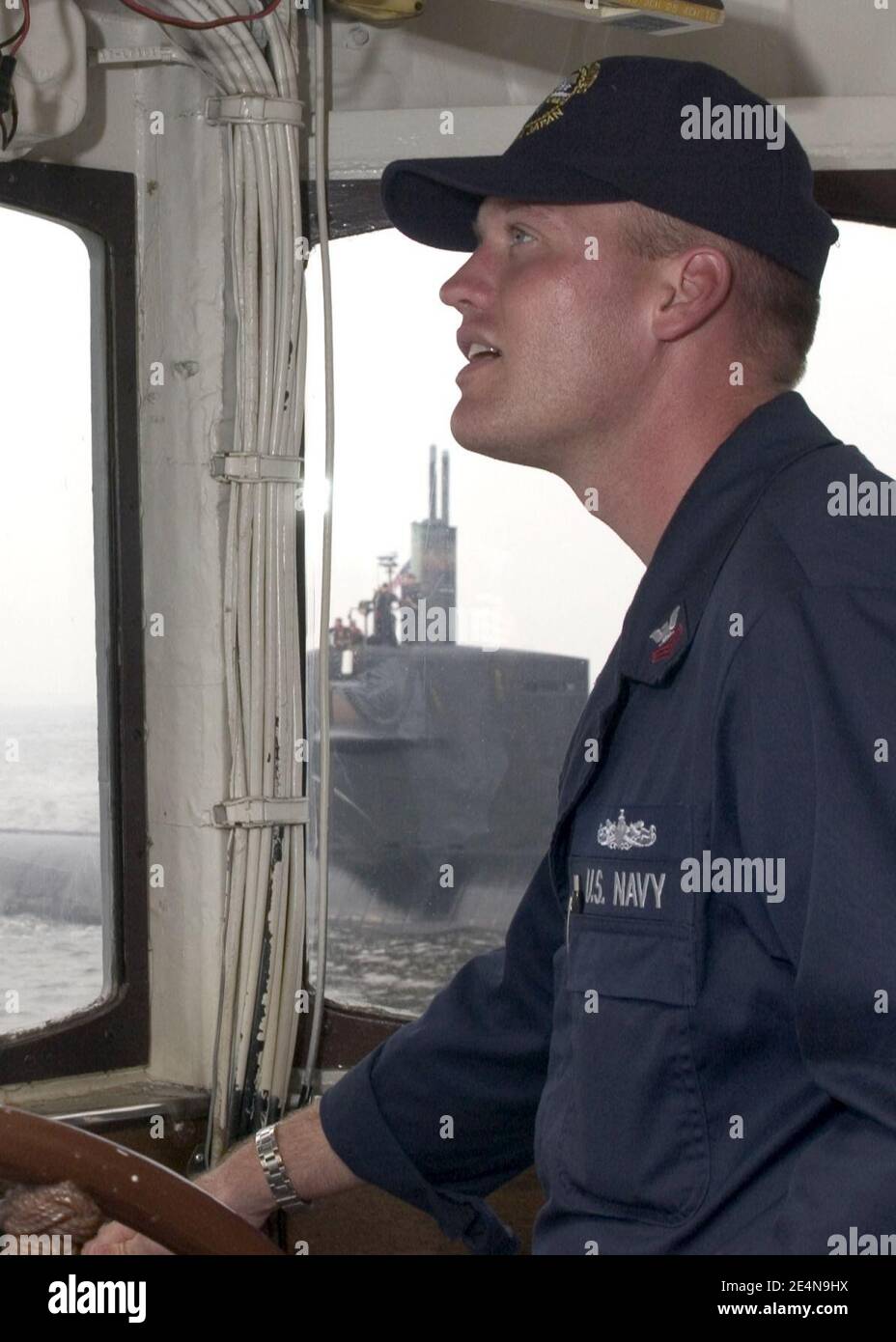 US Navy Boatswain's Mate 1st Class maneuvers the tugboat USS Opelika (YTB 798) as it approaches