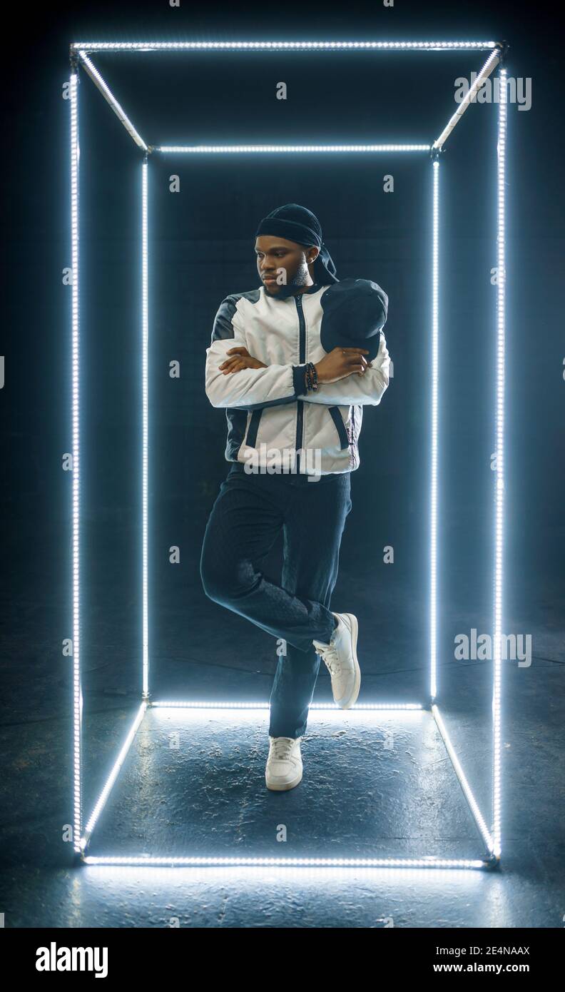 Rapper posing in illuminated cube, dark background Stock Photo - Alamy