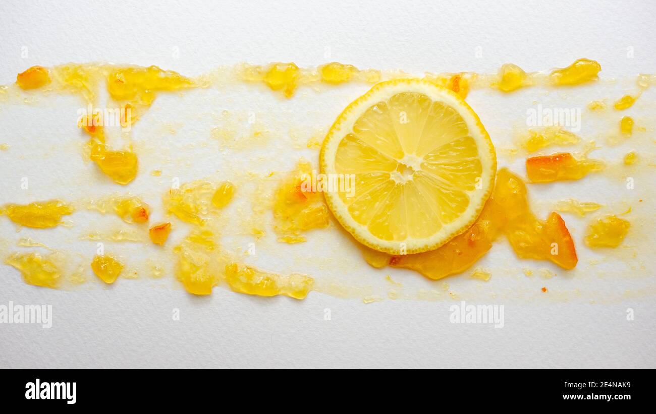 A slice of juicy lemon on citrus marmalade spread on the painting paper.  Food art. Close up Stock Photo - Alamy
