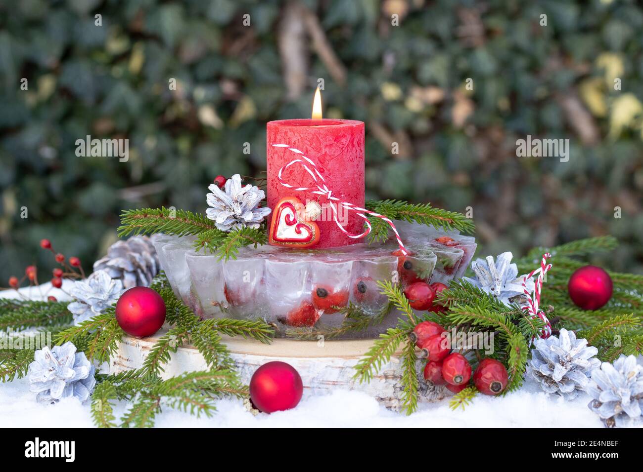 christmas garden decoration with ice lantern and red candle Stock Photo