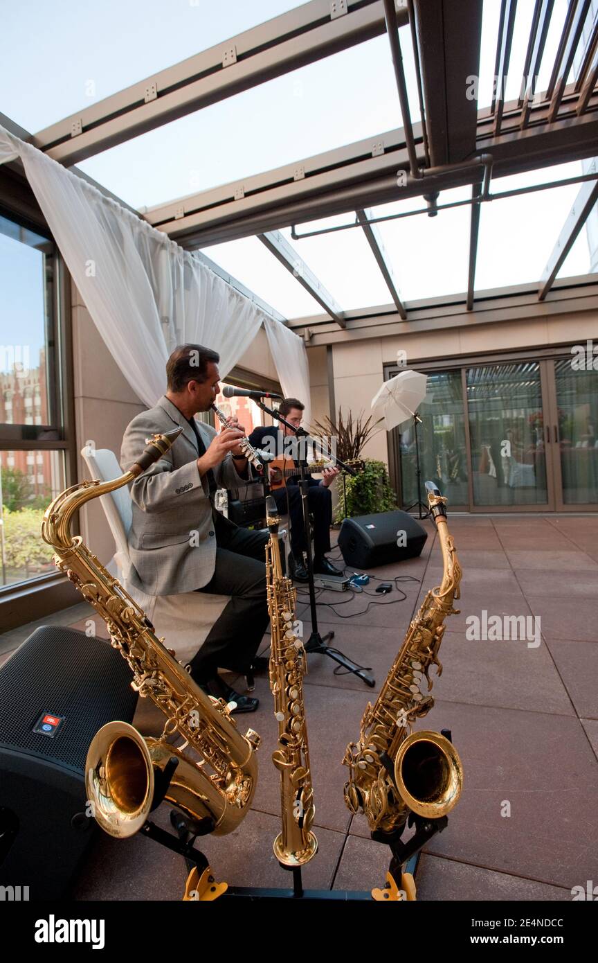 Duets of Saxophone and Guitar by Two Male Musicians at a Party Stock