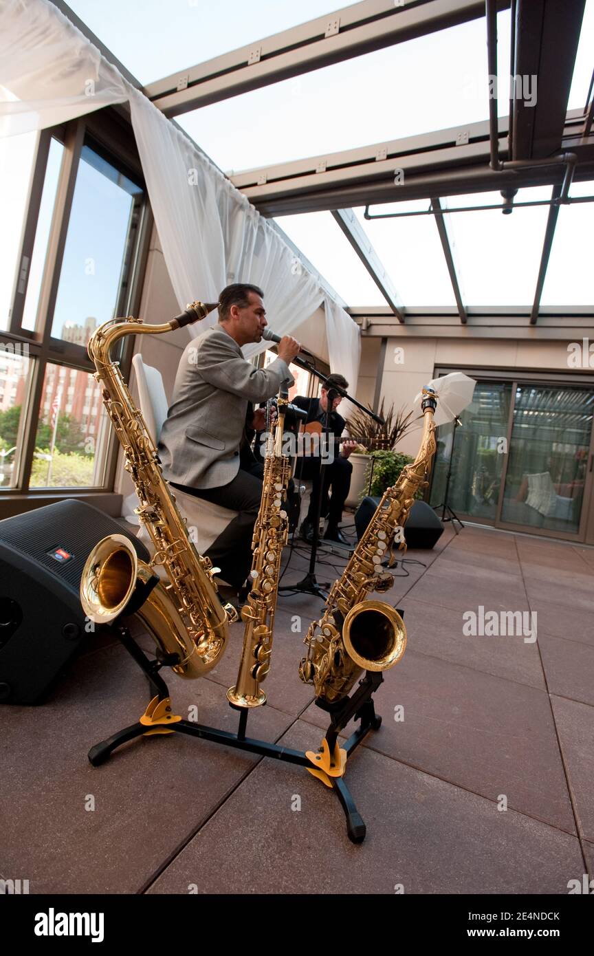 Duets of Saxophone and Guitar by Two Male Musicians at a Party Stock