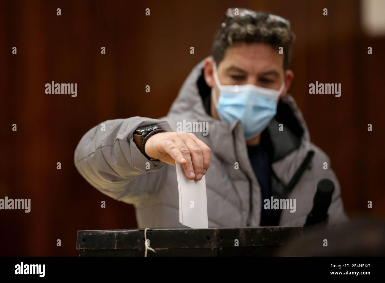 Lisbon, Portugal. 24th Jan, 2021. A man wearing a mask casts his ballot at a polling station in Lisbon, Portugal, on Jan. 24, 2021. Portugal's presidential election kicked off on Sunday, with nearly 11 million people eligible to vote and concerns over high abstention levels. Credit: Pedro Fiuza/Xinhua/Alamy Live News Stock Photo
