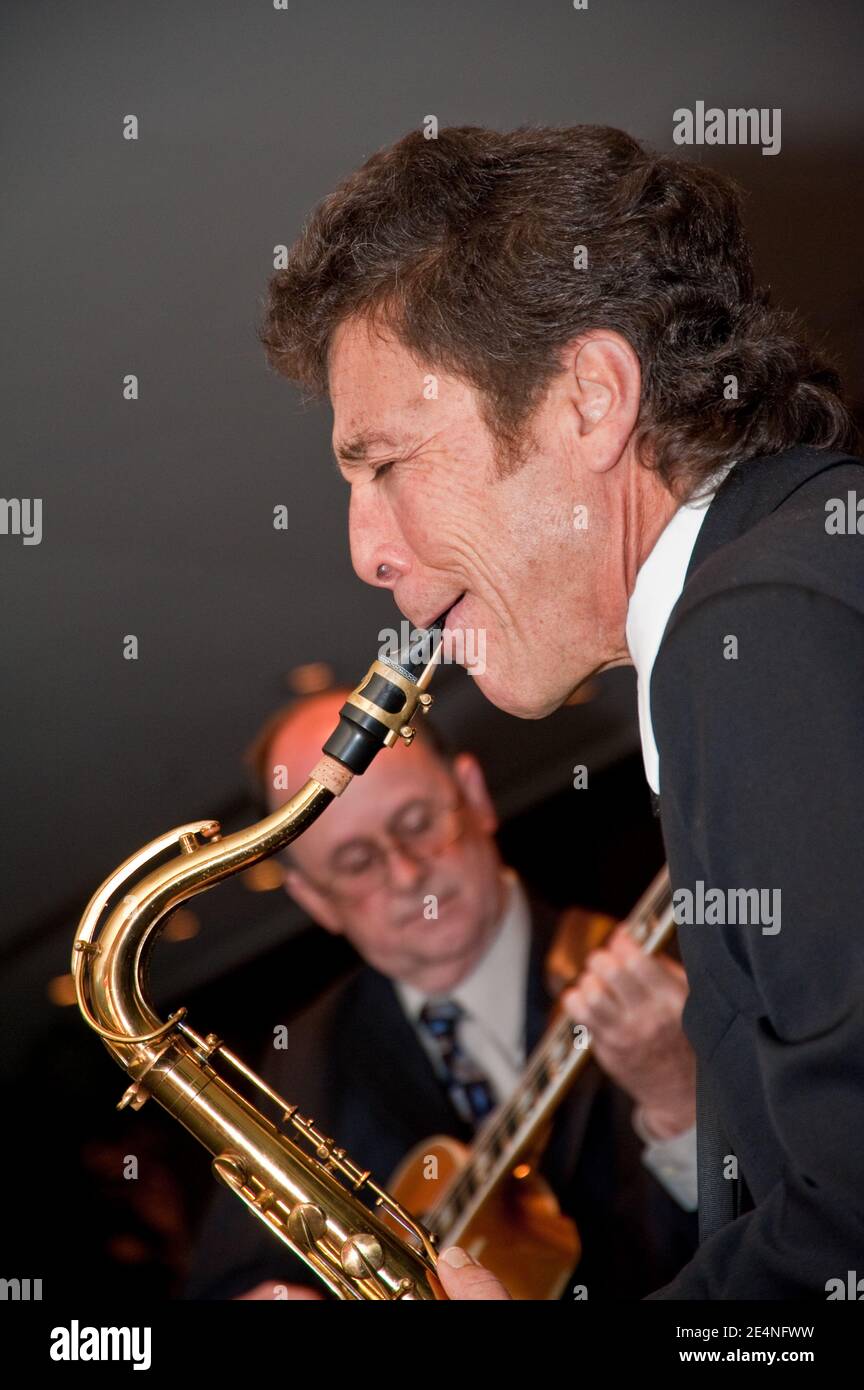 Duets of Saxophone and Guitar by Two Male Musicians at a Party Stock