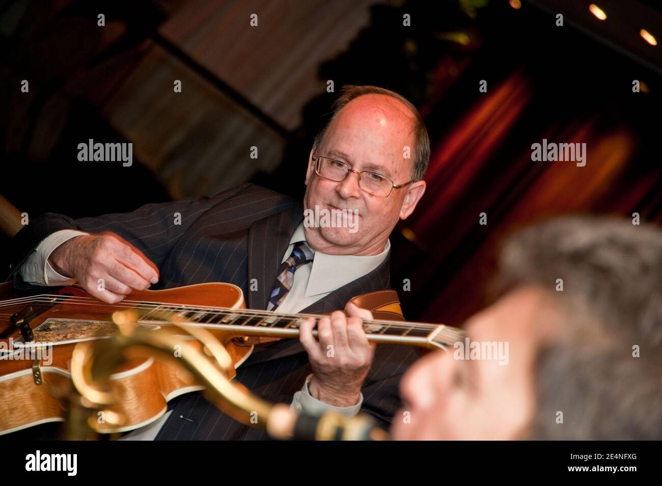 Duets of Saxophone and Guitar by Two Male Musicians at a Party Stock