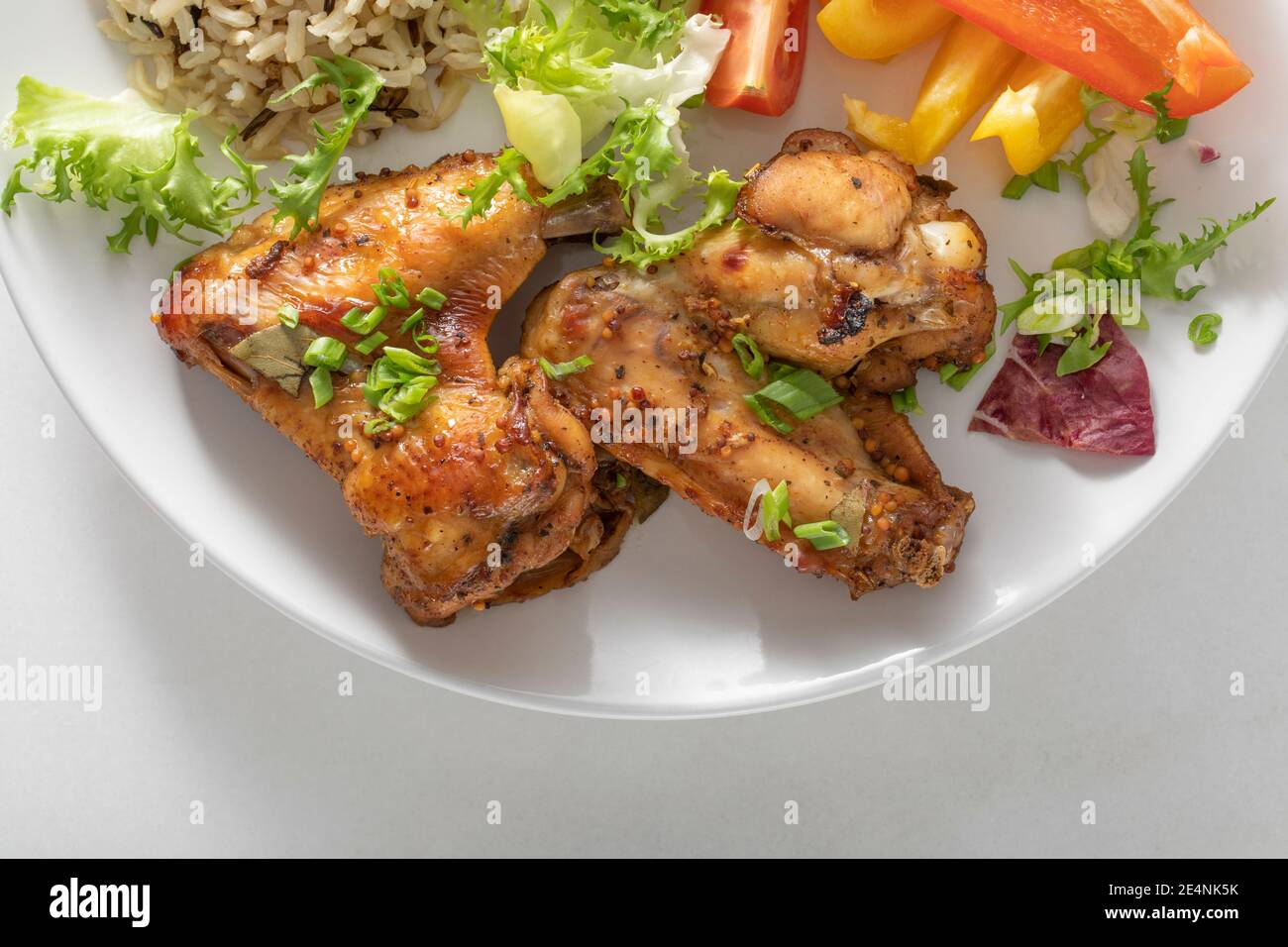 Baked chicken wings on a white background. A product high in protein