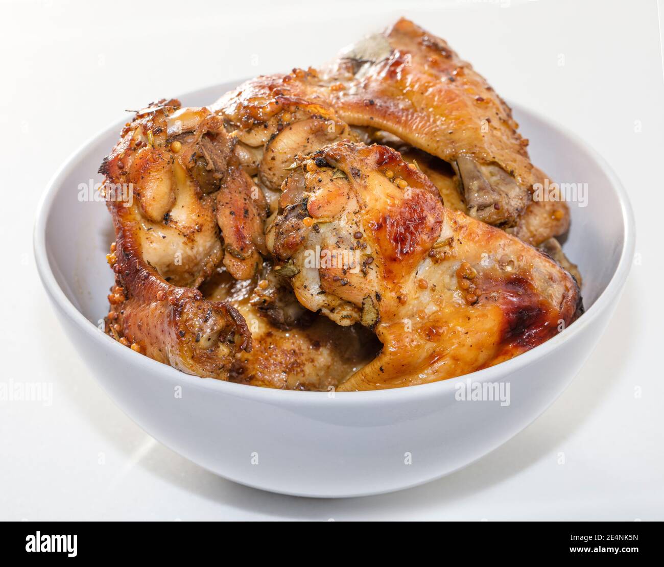 Baked chicken wings on a white background. A product high in protein