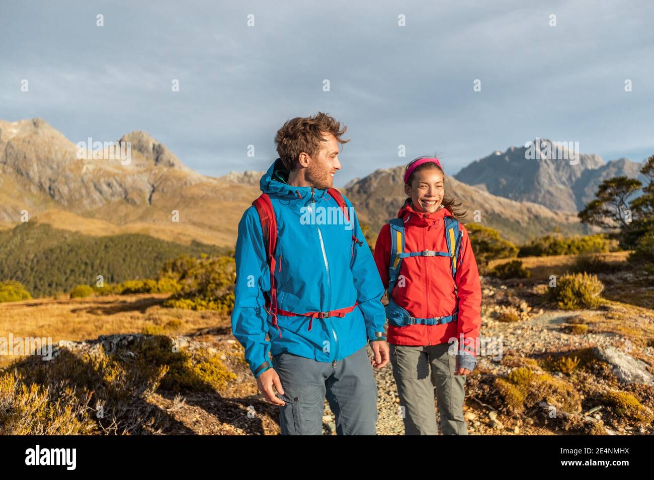 Hiking people walking living healthy outdoor active lifestyle doing hike at Routeburn Track. Multiethnic hikers with backpacks are tramping on Key Stock Photo