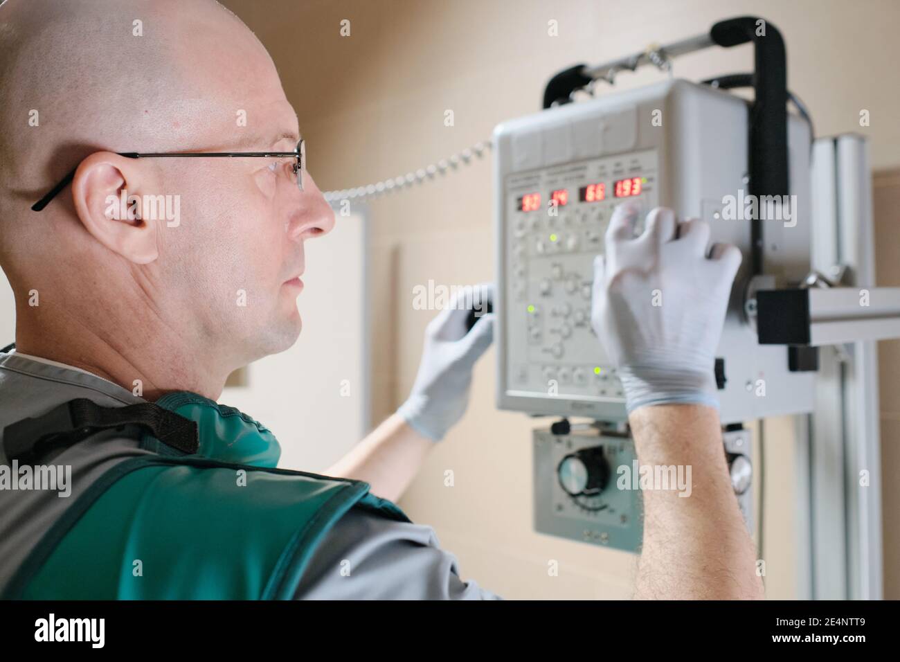 Serious mature doctor using x-ray equipment during his work at hospital Stock Photo