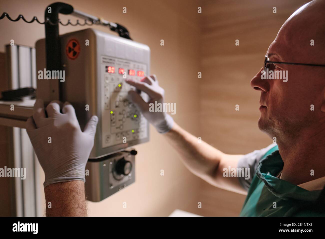 Mature engineer working with electric equipment hanging on the wall Stock Photo