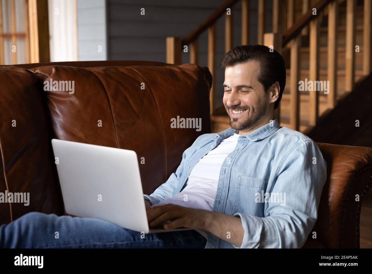 Smiling Caucasian man use computer talking on video call Stock Photo