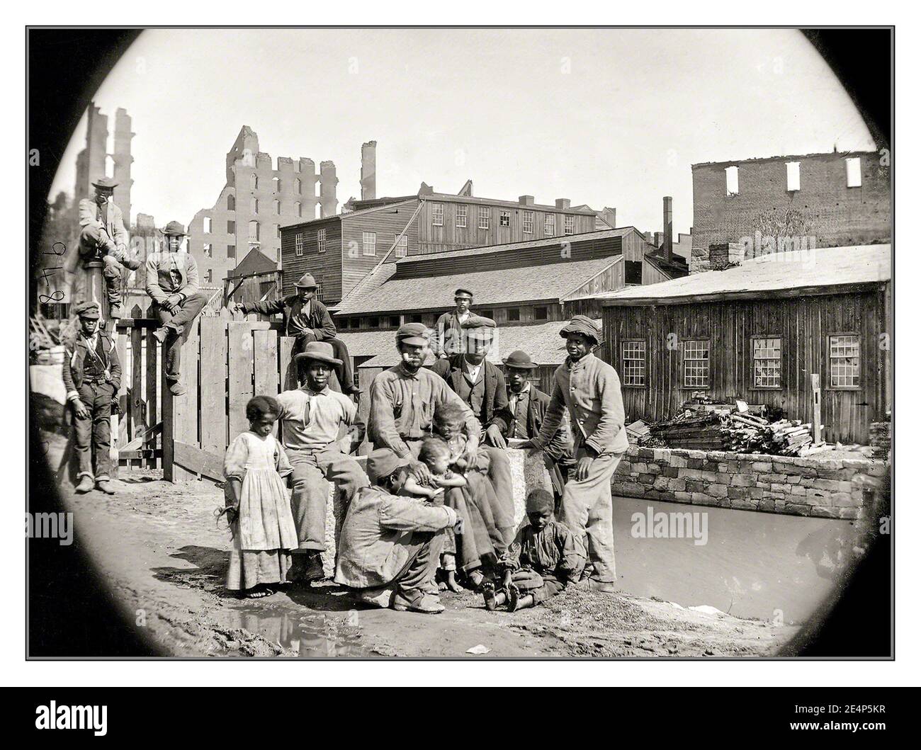 SLAVERY SLAVES AMERICA June 9, 1865. “Black African Americans freed from slavery group together for a photograph by a canal —  at Haxall’s Mill, Richmond.” USA Part of a Wet plate stereograph by Alexander Gardner. Stock Photo