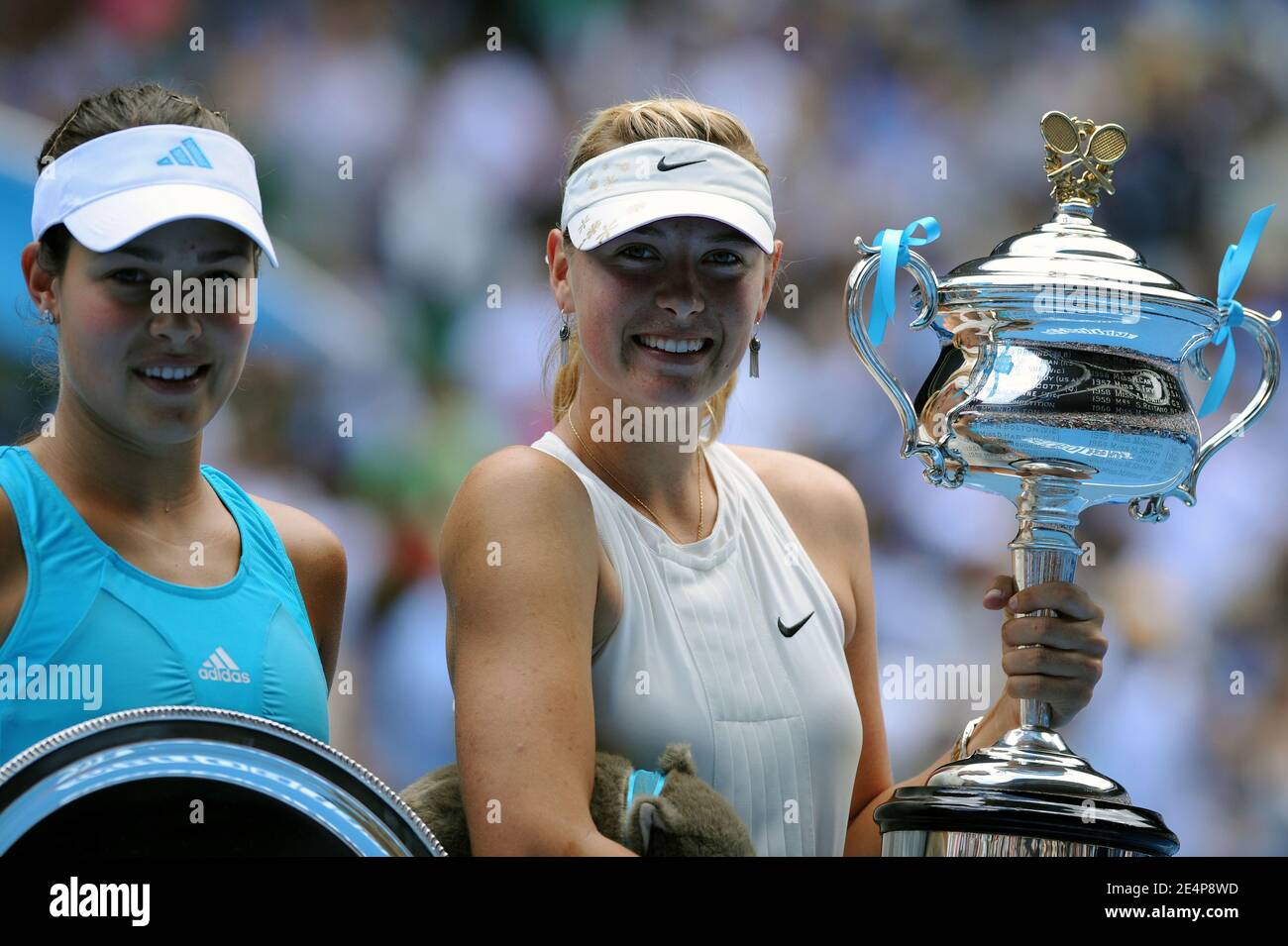 Sharapova (R) and Serbia's opponent Ana Ivanovic pose with their respective following their womens singles final match the Australian Open tennis tournament in Melbourne, Australia on January 26,