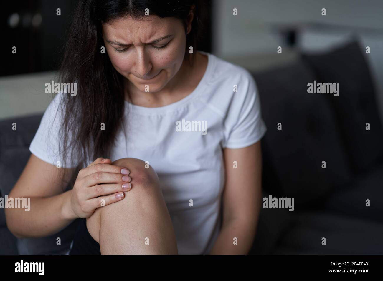 Closeup of a person massaging an injured knee joint. Bruise on the