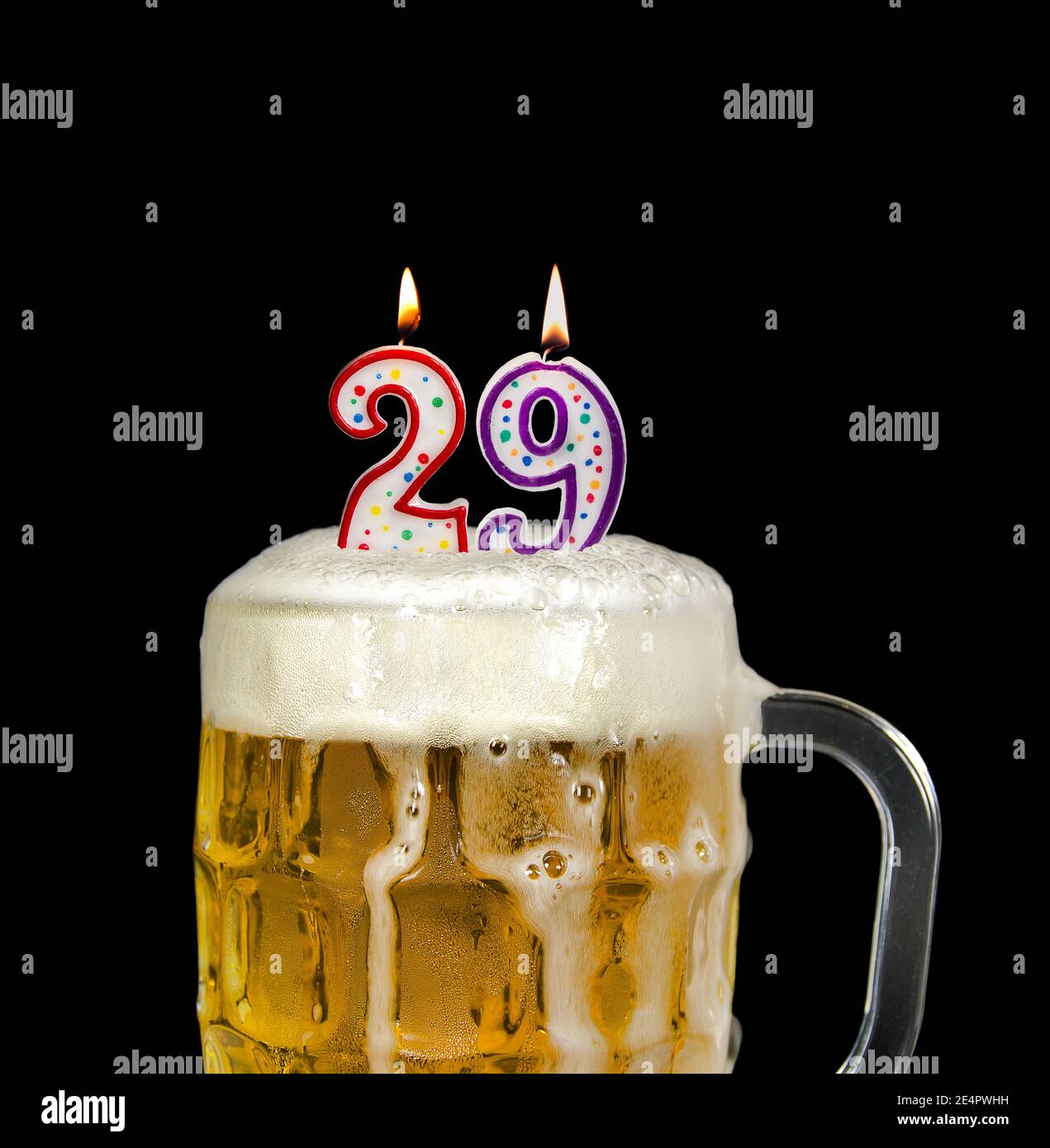 number 29 candles in beer mug for birthday celebration isolated on black Stock Photo