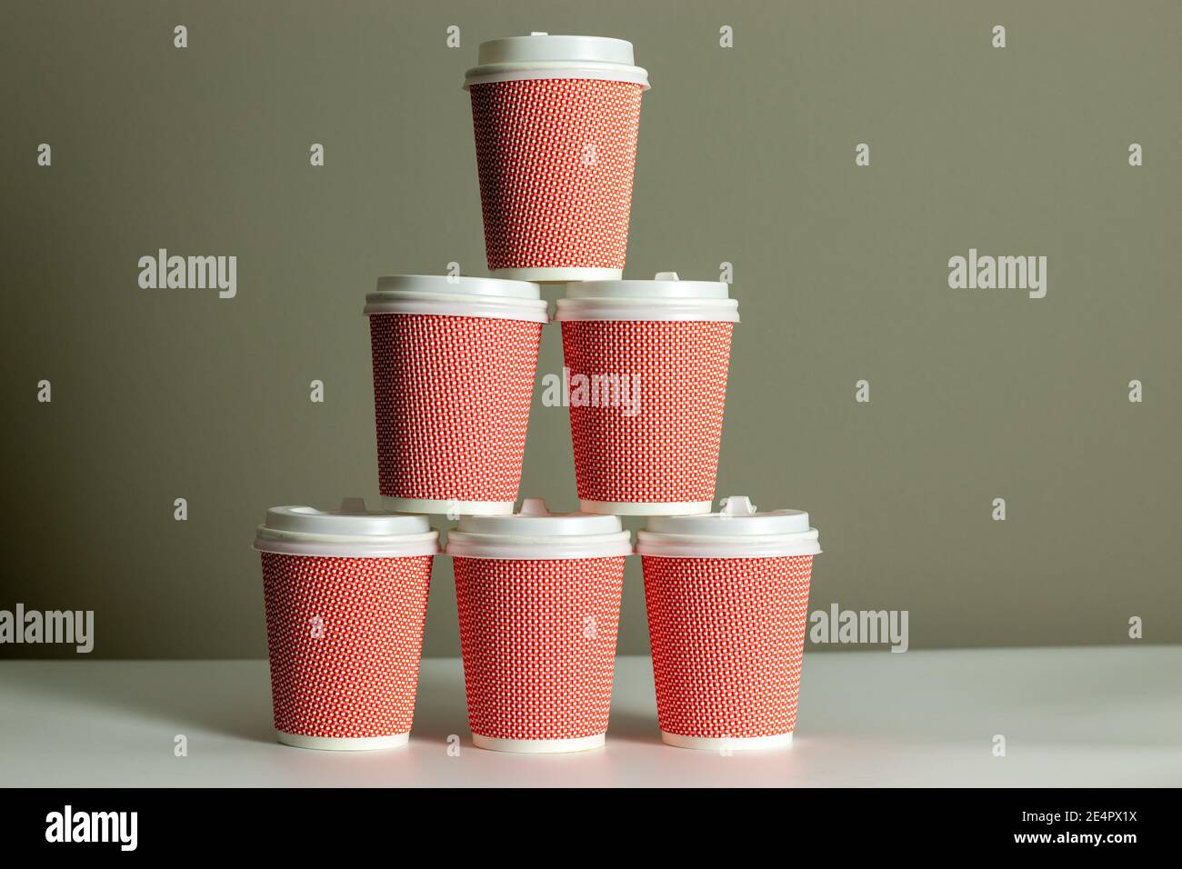 Pyramid of coffee cups with gray background. Cup of coffee. Takeaway or takeout business Stock Photo