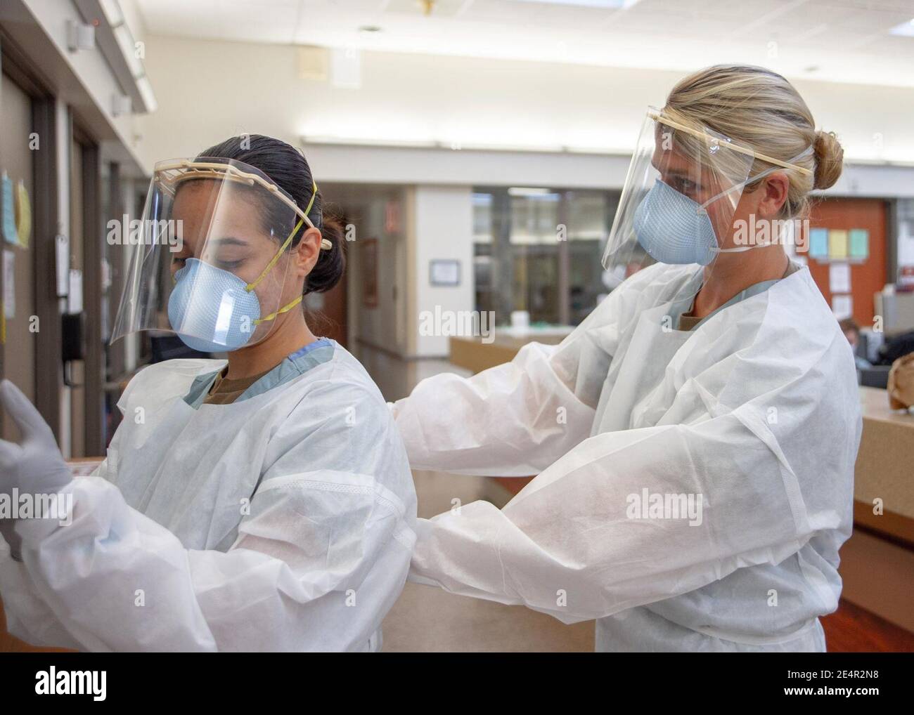 Medical personnel don PPE before entering a COVID-19-positive, non-critical patient s room. (50199060167). Stock Photo