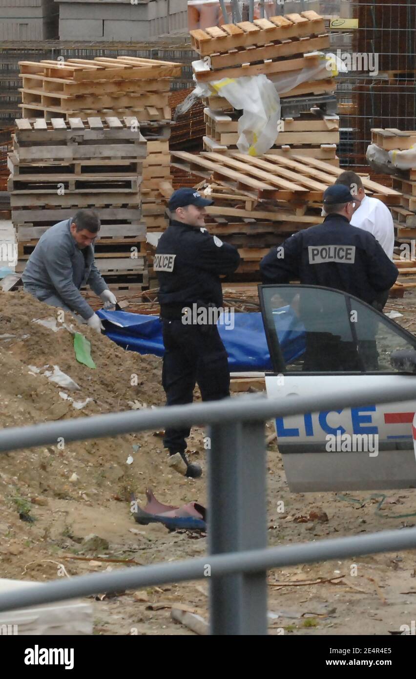 Forensic officers lift up the body of an unidentified woman, alledgedly