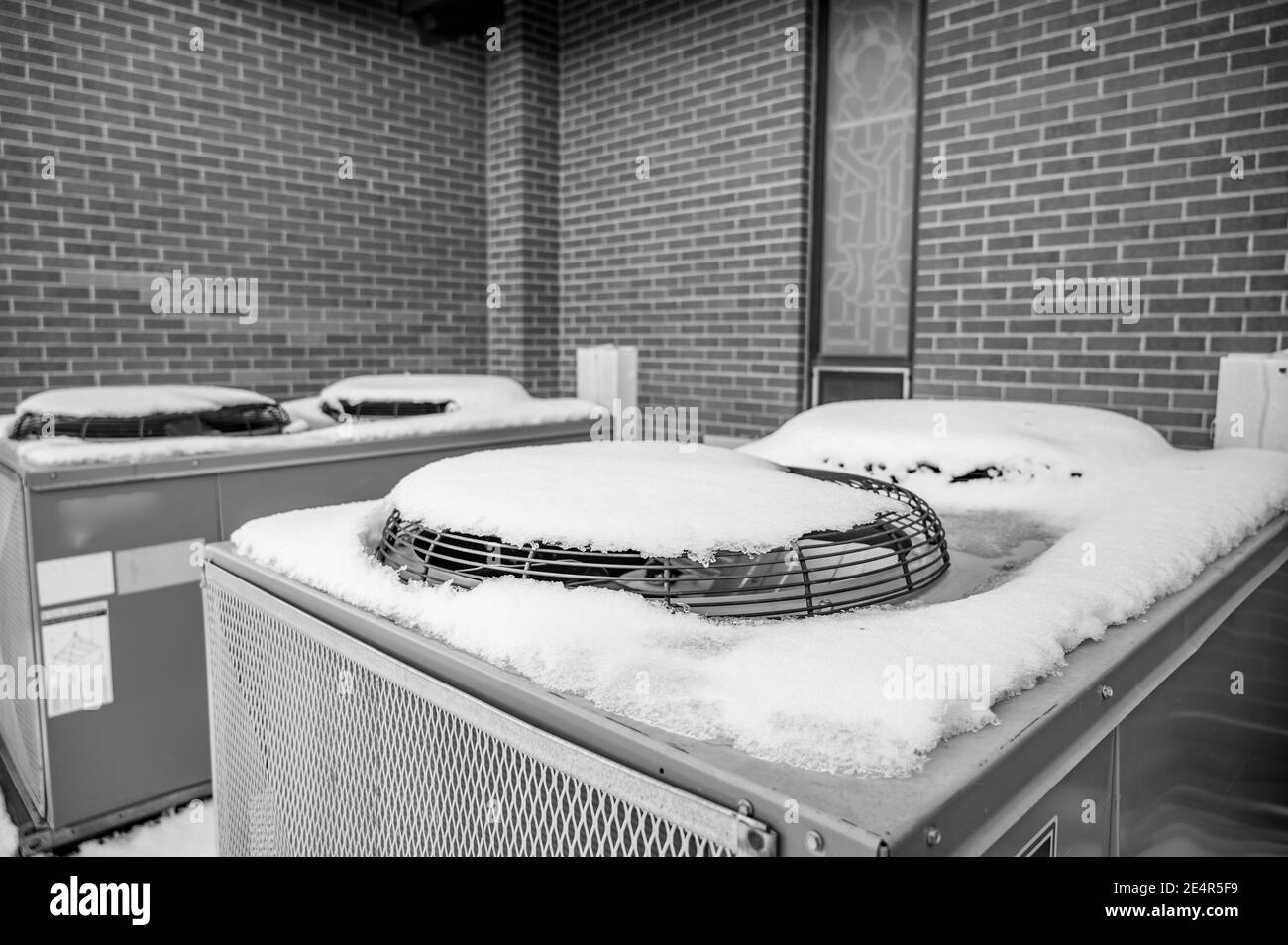 Outdoor snow covered AC units not in use during the winter - tune-up reminder Stock Photo