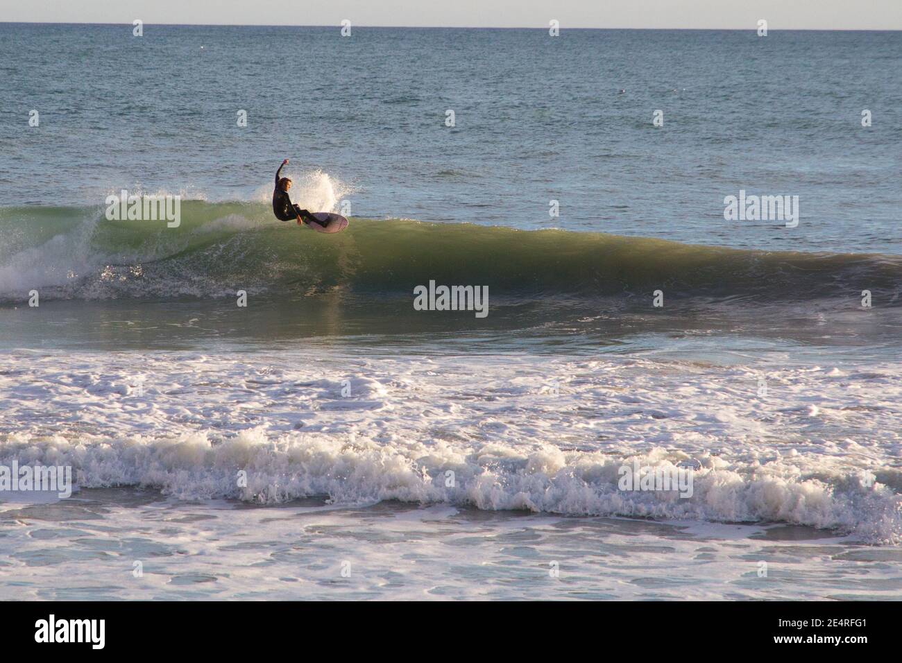 Surfer surfing wave jumping on surf board. Mallorca Spain Stock Photo