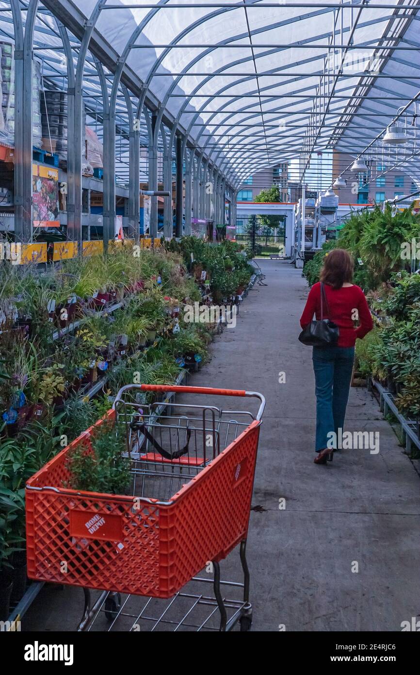 Toronto, Canada, Aug 2007 - Woman in red shirt looking for plants to buy at a Home Depot garden centre Stock Photo