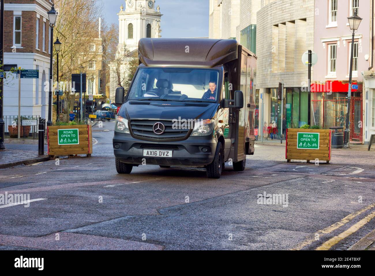 UPS delivery van drove through two road planters with 'road open to' sign in green background in low traffic neighbourhood, London Stock Photo