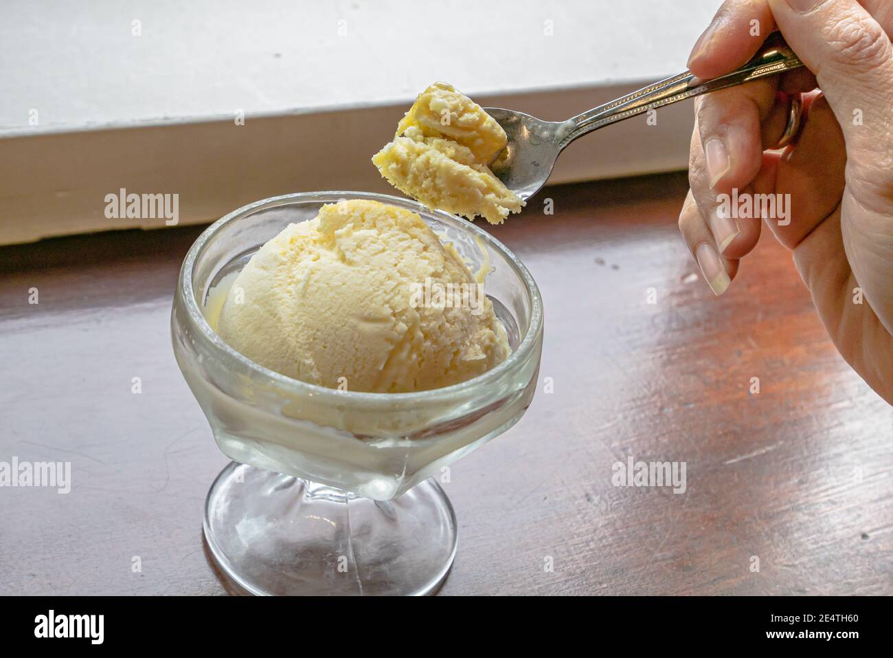 https://c8.alamy.com/comp/2E4TH60/the-close-up-of-tasty-homemade-cool-vanilla-ice-cream-scoop-in-glass-cup-on-vintage-wood-table-background-2E4TH60.jpg