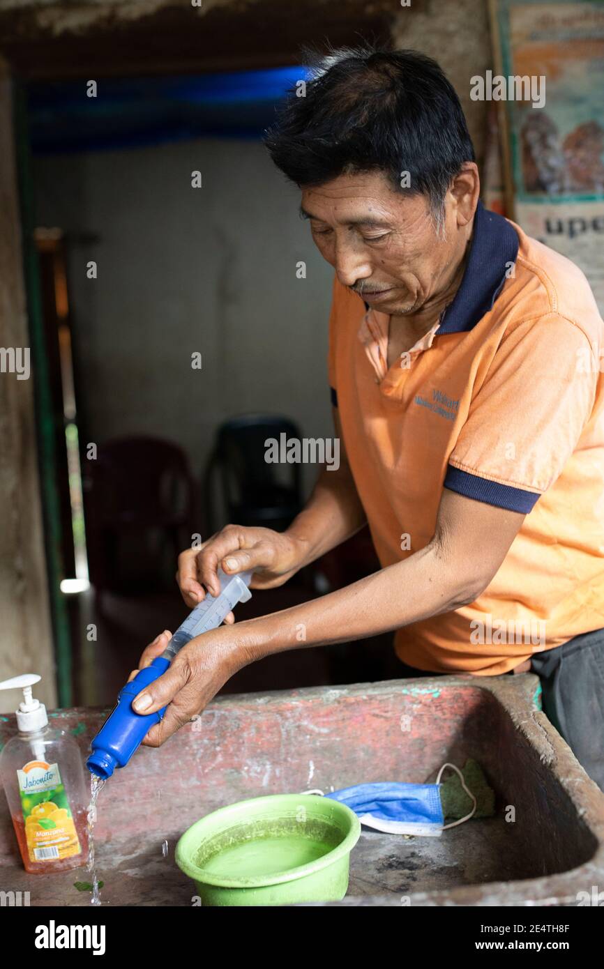 Backwash cleaning a home tap-based water filter system in use in San Juan la Laguna, Guatemala. Stock Photo
