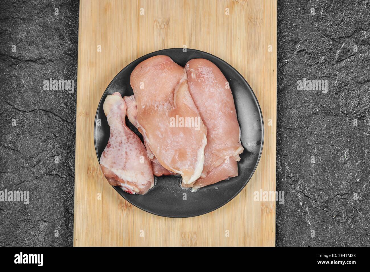 Plate of raw chicken parts on wooden chopping board Stock Photo Alamy
