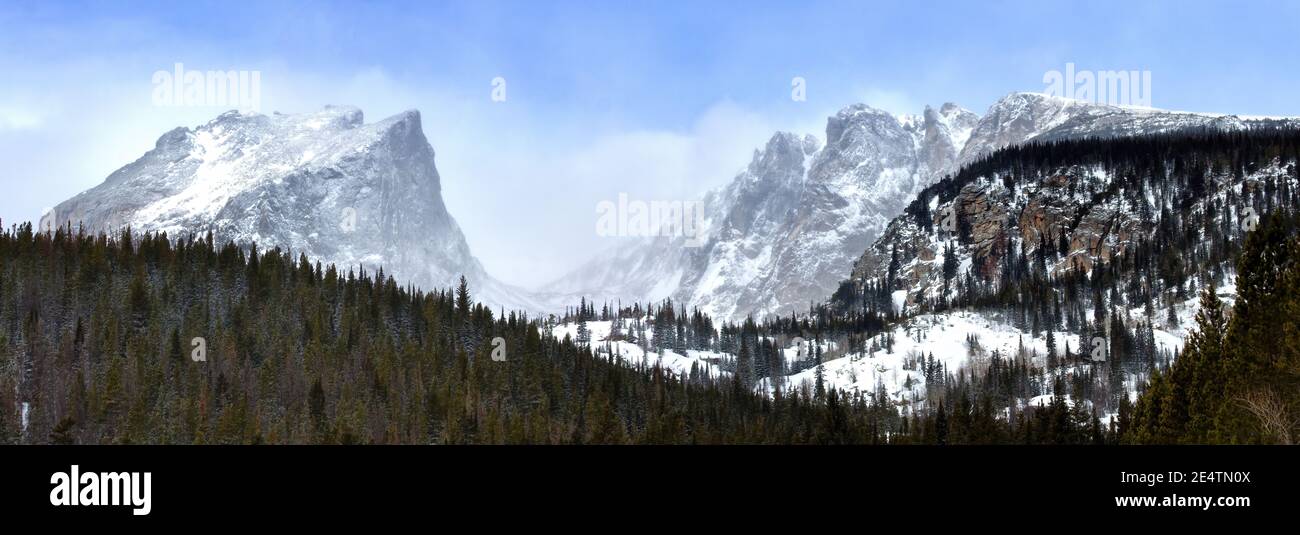 Panorama of Hallet Peak and Flattop as viewed from Rocky Mountain National Park as snow blows over the mountain peaks Stock Photo