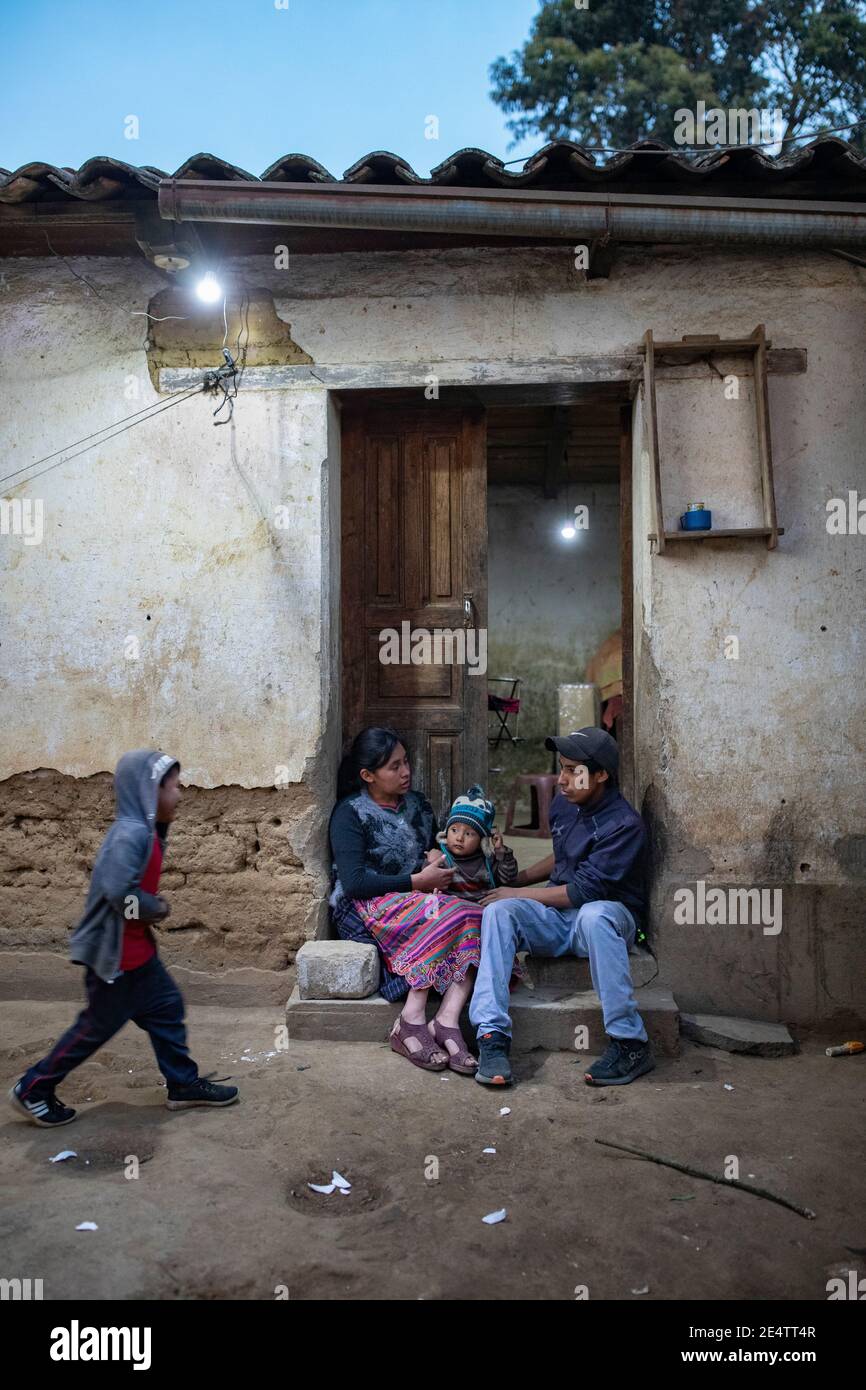 Family using a new solar-powered lighting system at their home in Cantel, Guatemala, Central America. Stock Photo