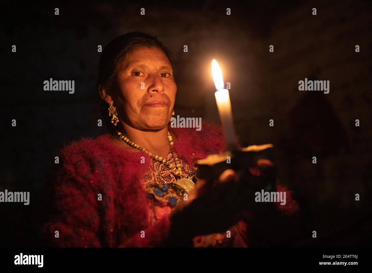 A woman uses a candle as a light source at her home in Cantel, Guatemala, Central America. Stock Photo