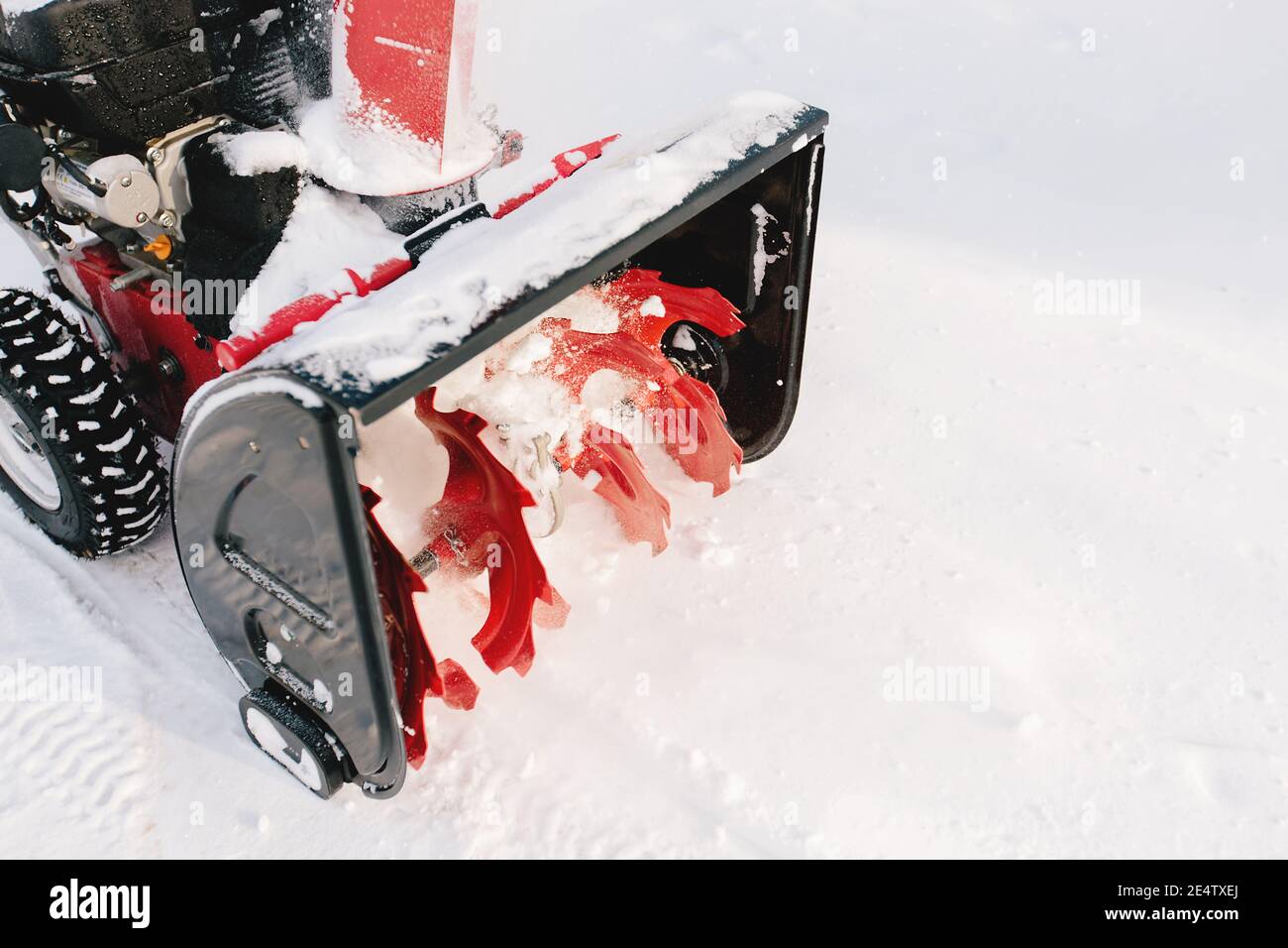 Red-black snowblower machine in the process of work Stock Photo