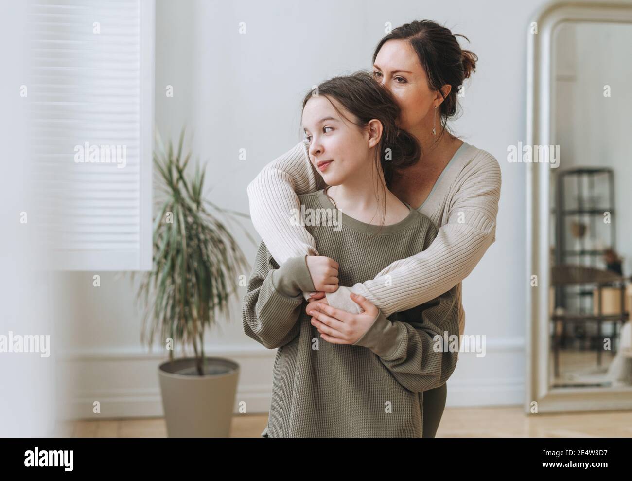 Portrait of mother middle age woman and daughter teenager together in light interior Stock Photo