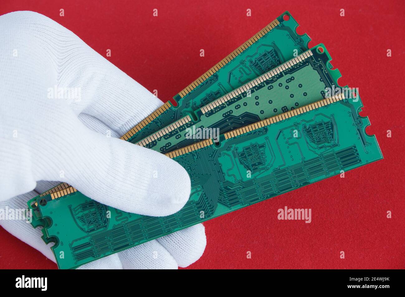 Hand in white glove holds a three computer memory card. Closeup. Stock Photo