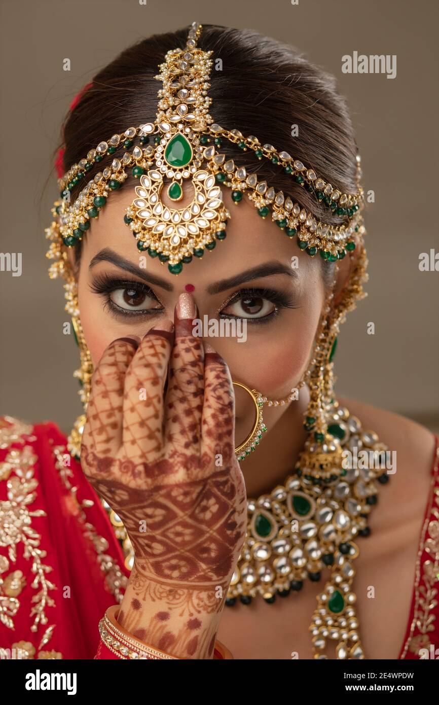 Beautiful Indian bride putting a bindi ...