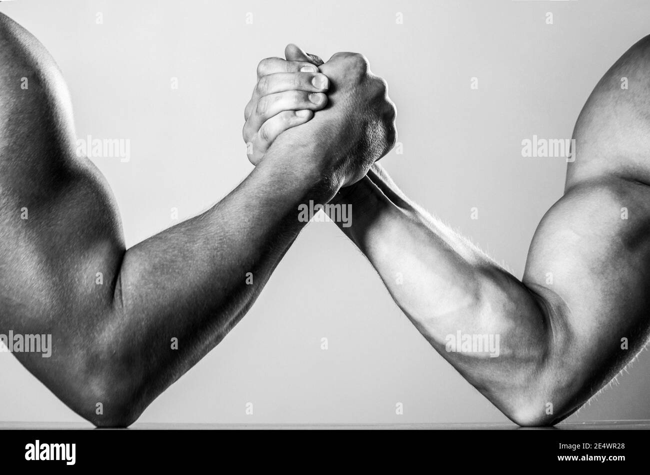 Muscular men measuring forces, arms. Hand wrestling, compete. Hands or