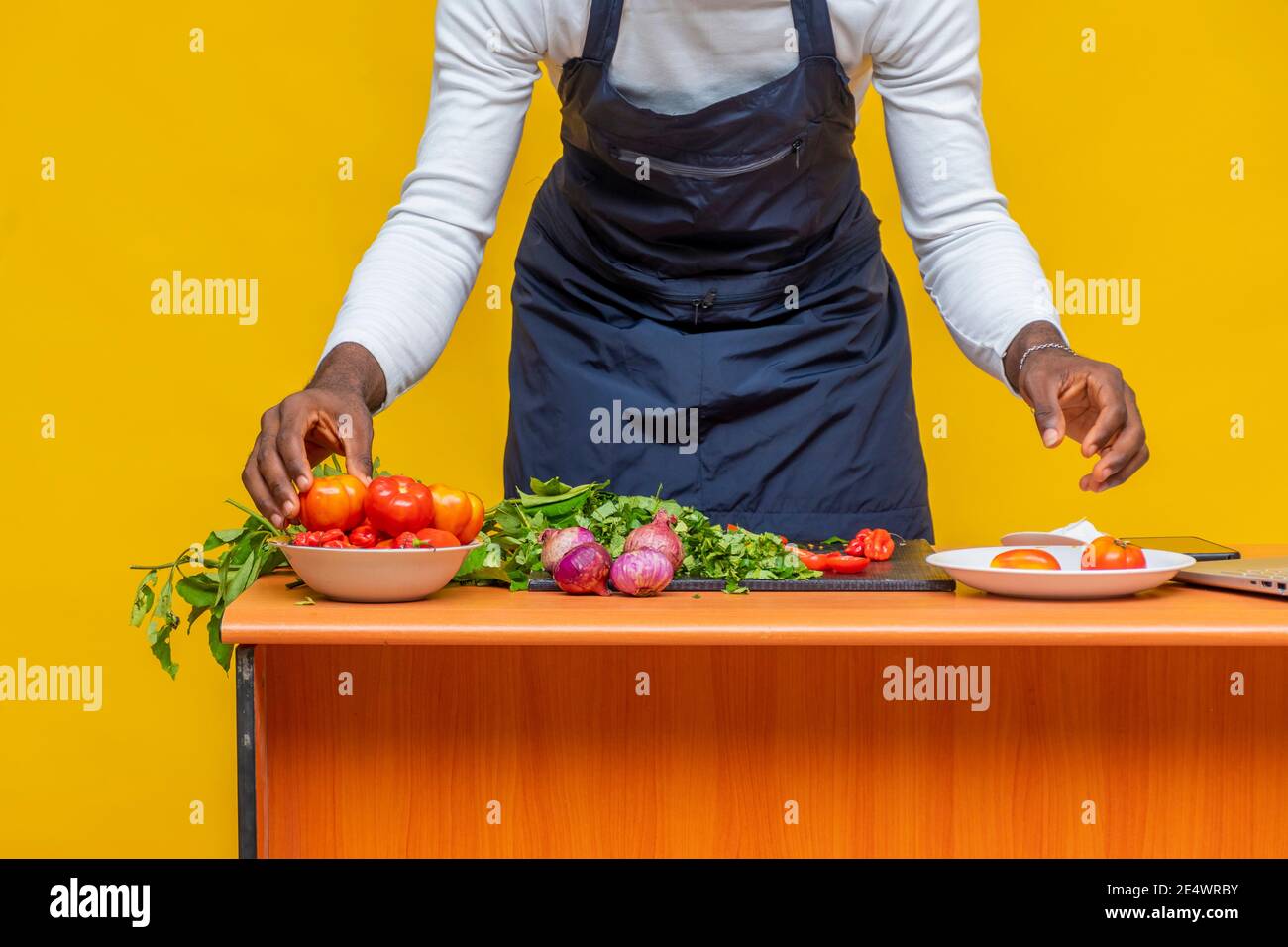 ingredients on a table in front of a black chef who's sorting them pout ...
