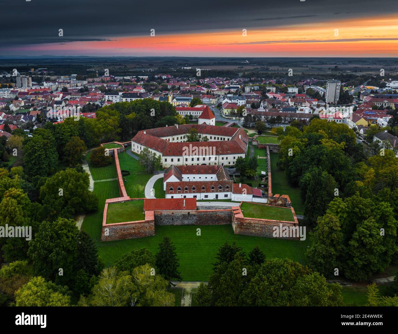 Sarvar, Hungary - Aerial panoramic view of the Castle of Sarvar (Nadasdy castle) with a beautiful dramatic sunrise at background on a summer morning Stock Photo