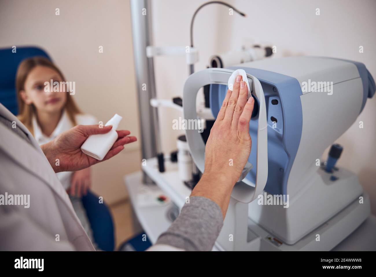 Doctor preparing special device for checking eyes in optician center