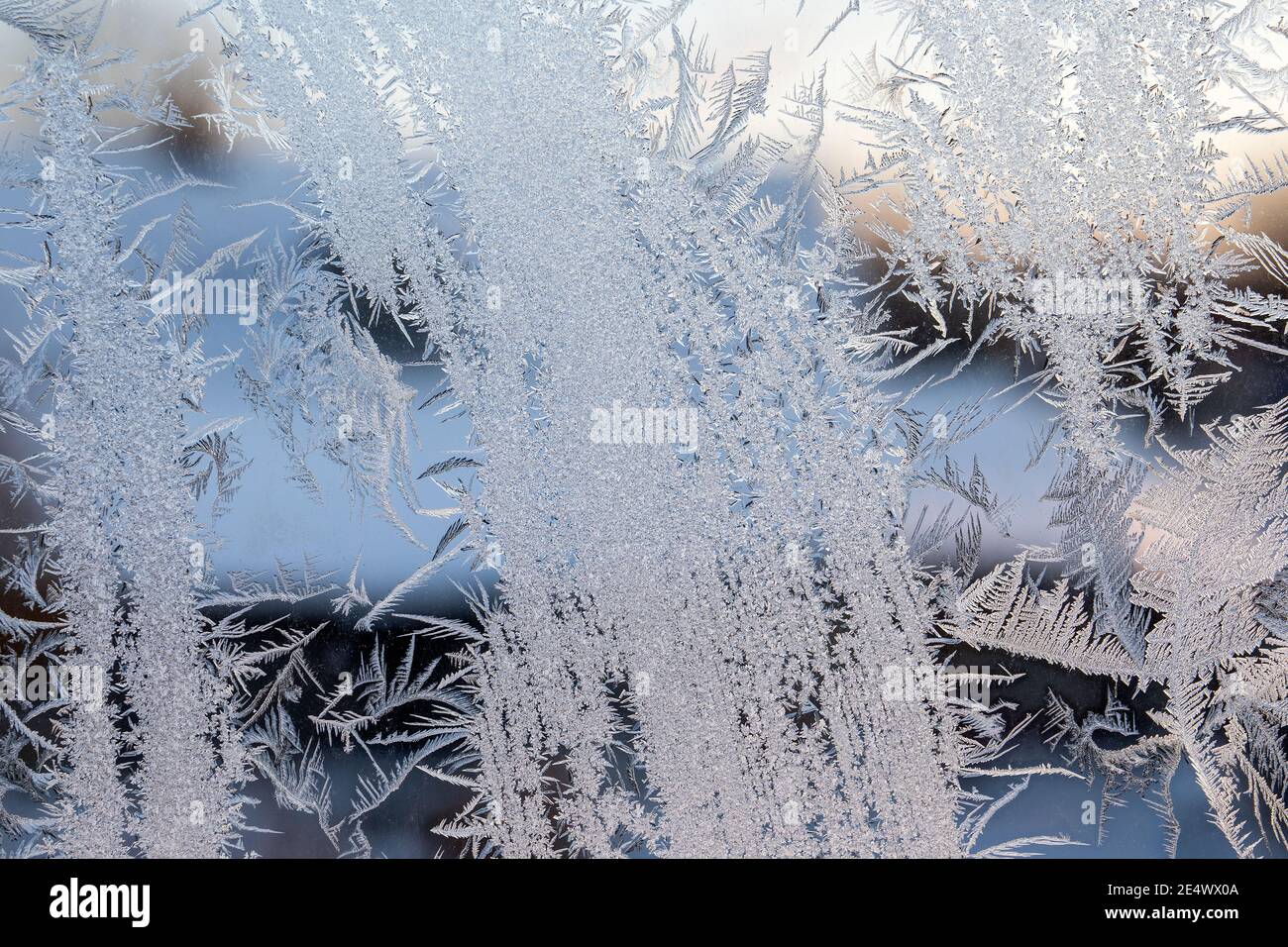 Heating season. Ice flower on a frozen window. Energy efficiency and weather conditions. Stock Photo