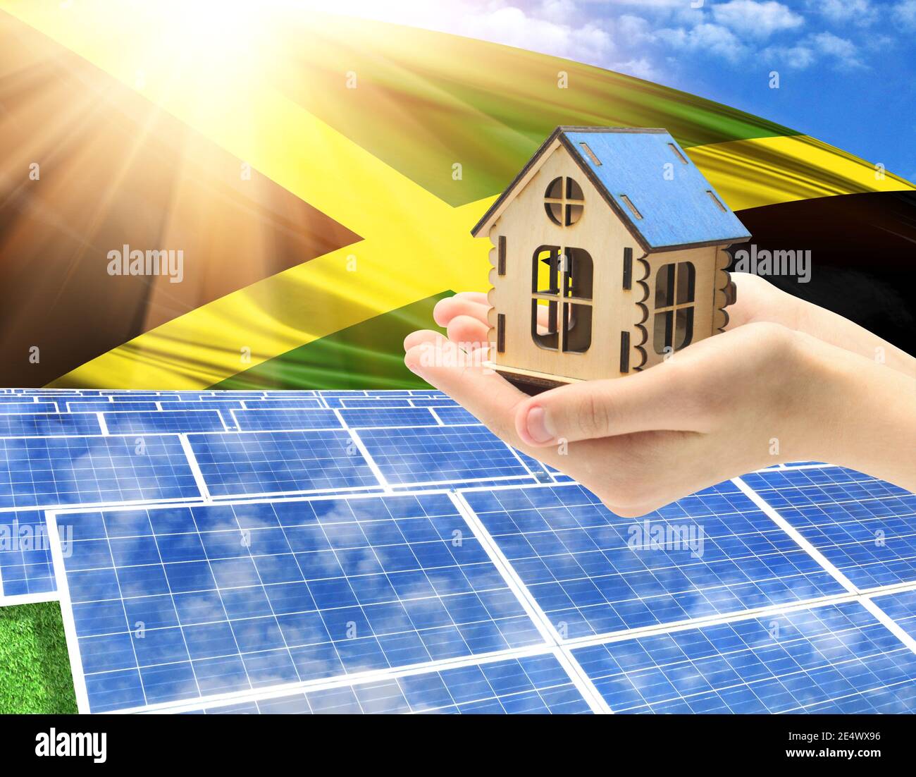 The photo with solar panels and a woman's palm holding a toy house