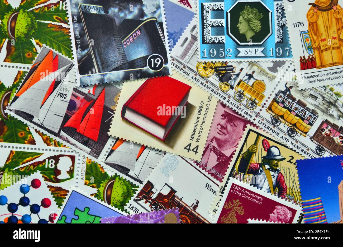 A jumbled mixture of past British commemorative postage stamps which people may collect or use to send letters and parcels through the Royal Mail Stock Photo